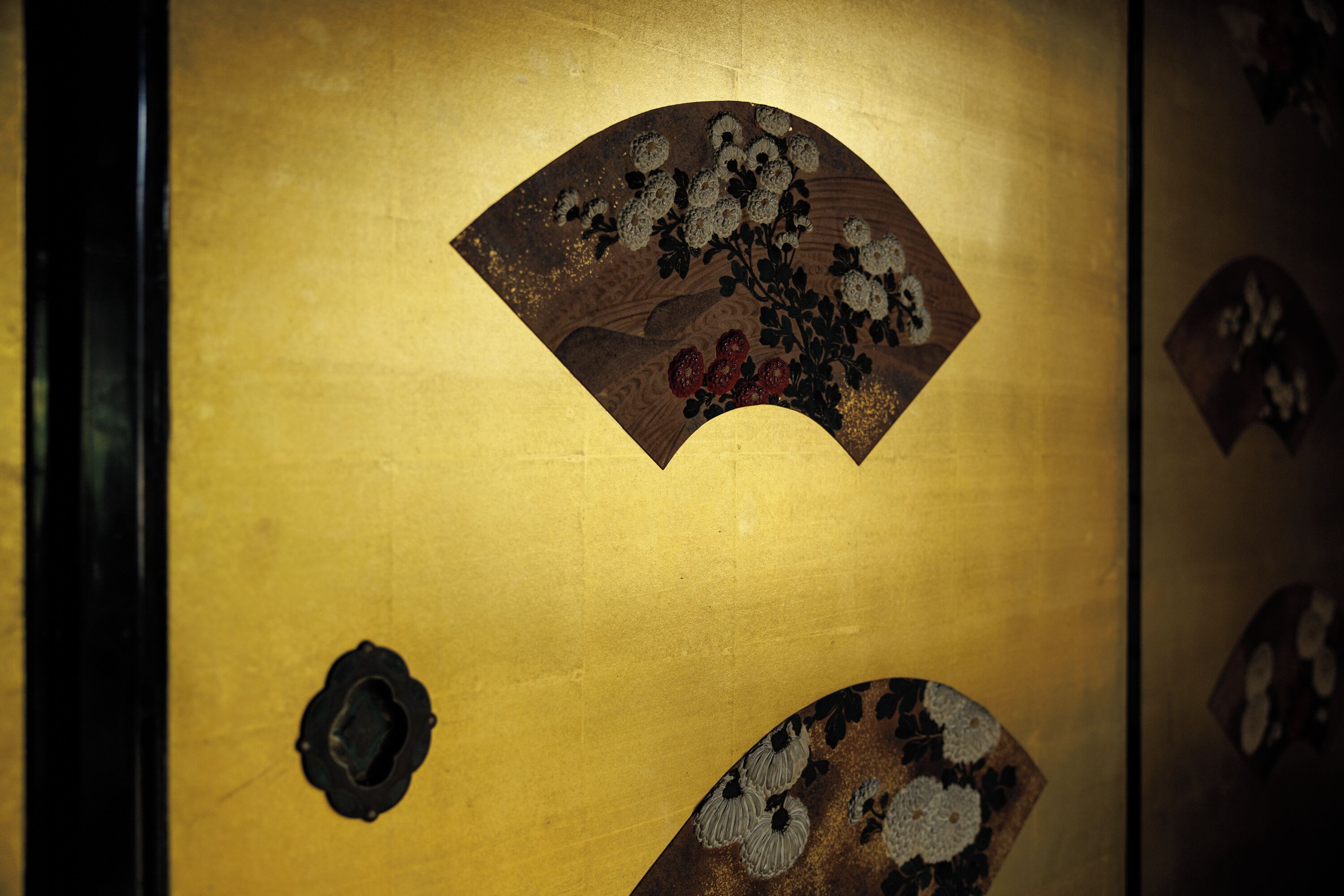 A golden door with traditional artwork and a circular handle.