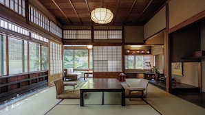A traditional Japanese room with tatami flooring, a low table, and sliding doors. - Hiiragiya (Kyoto)