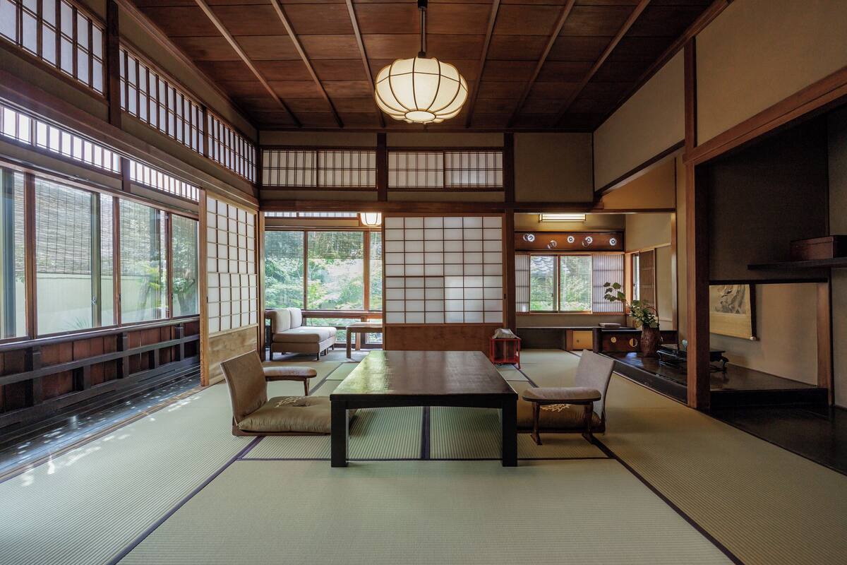 Une pièce de style japonais traditionnel, avec un sol recouvert de tatamis, une table basse et des portes coulissantes.