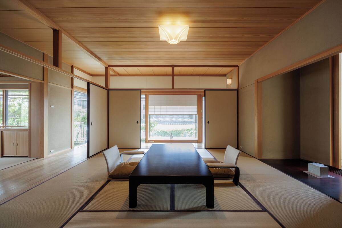 Une pièce de style japonais traditionnel, avec un sol recouvert de tatamis, une table basse et des portes coulissantes.