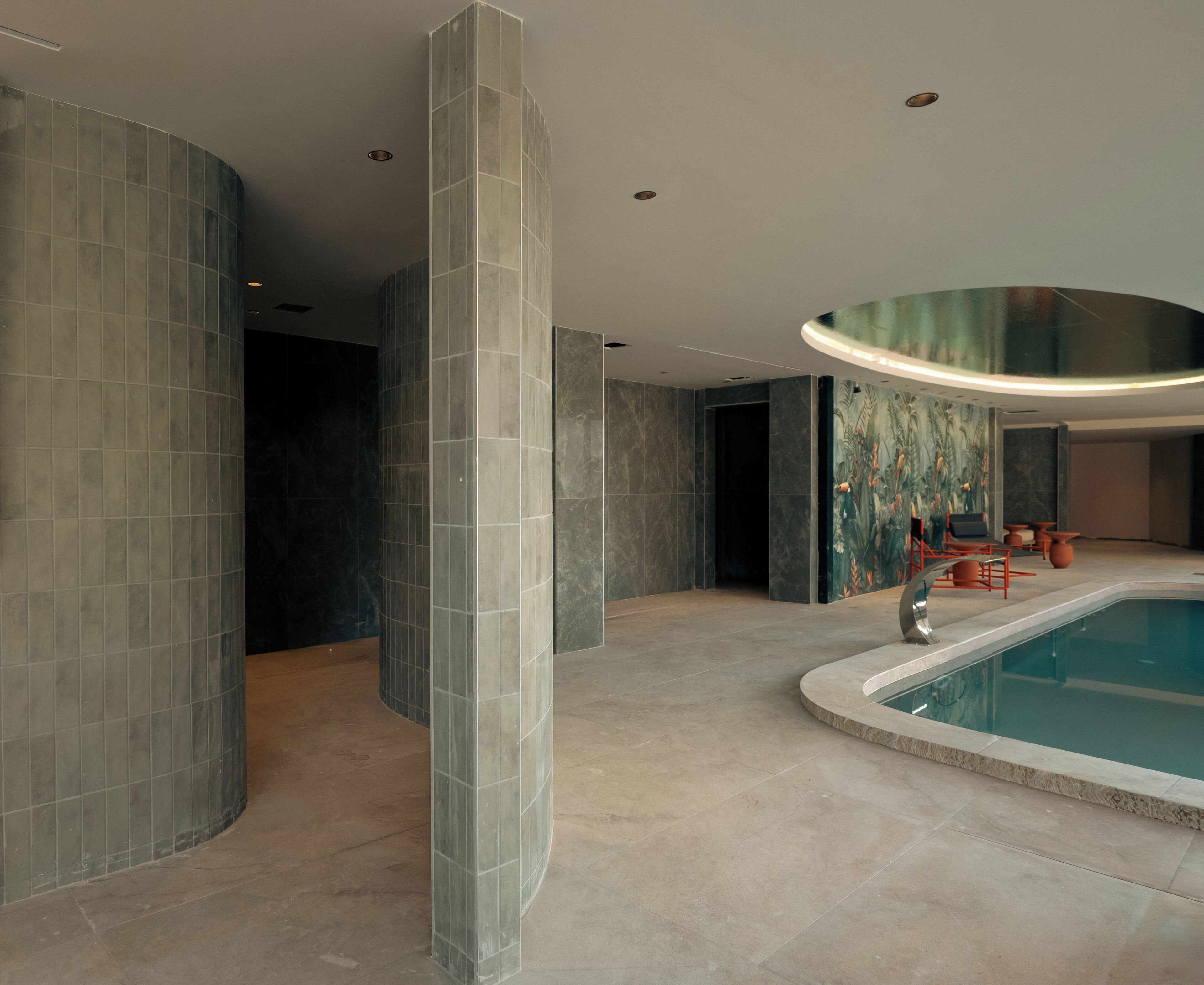 Un interior moderno con piscina, paredes curvas e iluminación empotrada.
