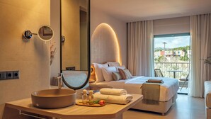 A modern hotel room with a large bed, a bathroom with a round sink, a mirror, and a view of the outside. - Zeus Eleva Kassandra Lagoon (Kassandra)