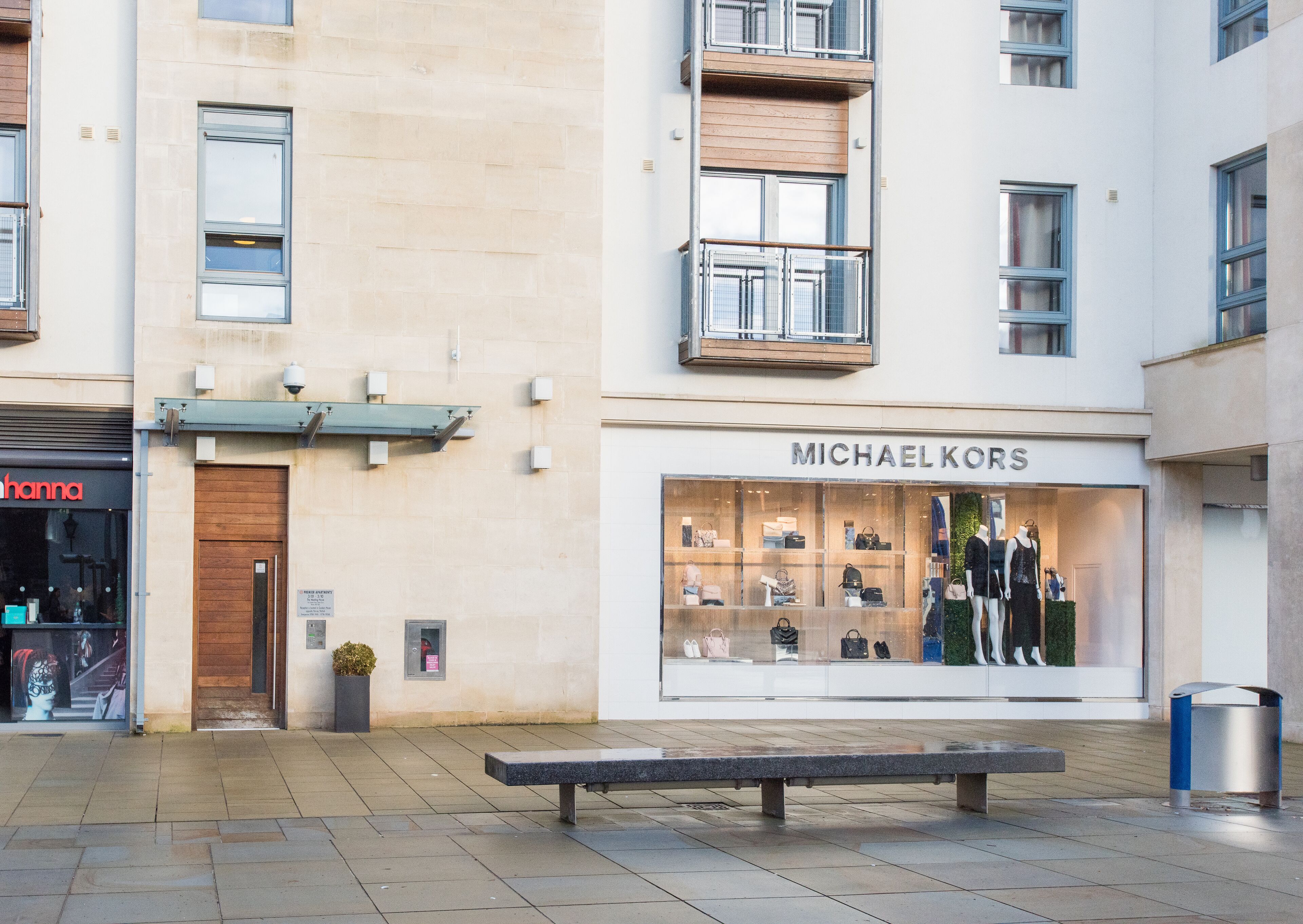 A Michael Kors store with a display window showcasing handbags and shoes.