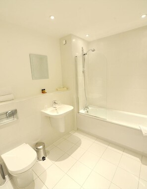 A modern bathroom with a toilet, sink, and bathtub.