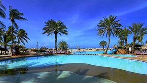 A pool area with lounge chairs, palm trees, and a view of the beach. - Sunsol Punta Blanca (San Pedro)
