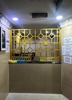 A reception desk with a decorative golden partition, a blue basket, and a white sign indicating checkout time.