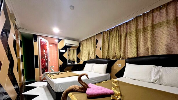 A hotel room with two beds, a large mirror, and a decorative swan on the bed. - Kajang Star Hotel (Kajang)