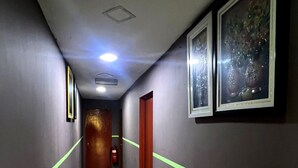 A hallway with grey walls, green lines, and framed artwork. - Kajang Star Hotel (Kajang)