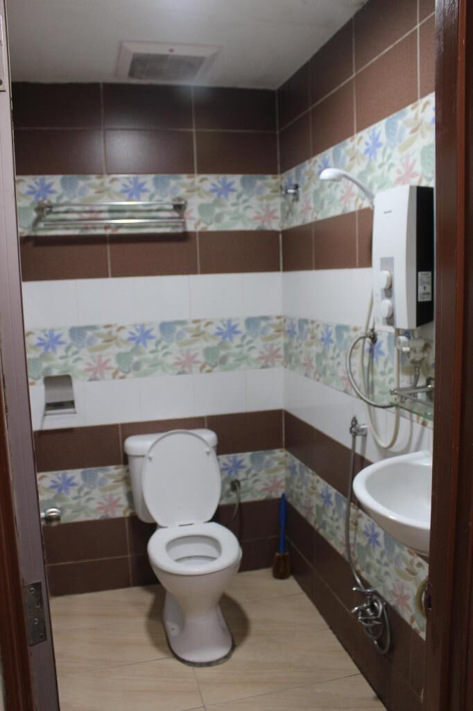 A small bathroom with a toilet, a sink, and a shower.