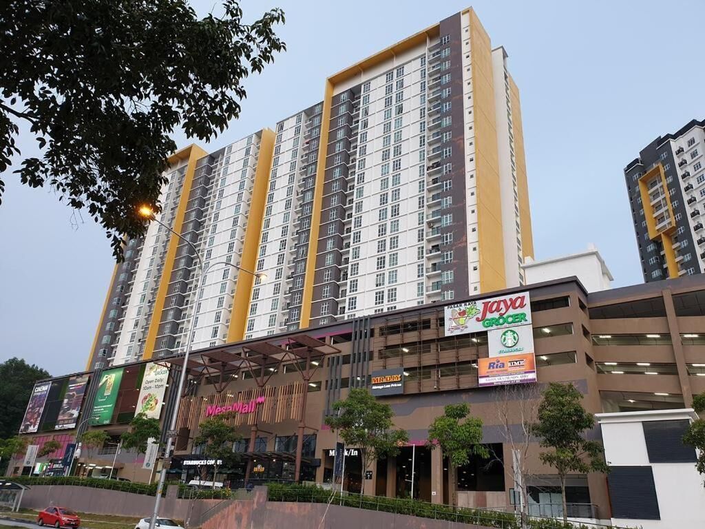 Un edificio de gran altura con varios pisos, rodeado de comercios, incluyendo una tienda de comestibles y una farmacia.