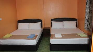 Una habitación con dos camas, cada una con cabecero negro y ropa de cama blanca.