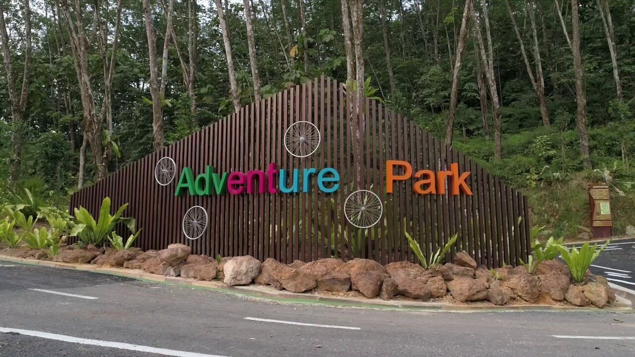 A wooden sign with the words "Adventure Park" and decorative wheels.