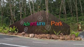 A wooden sign with the words "Adventure Park" and decorative wheels.