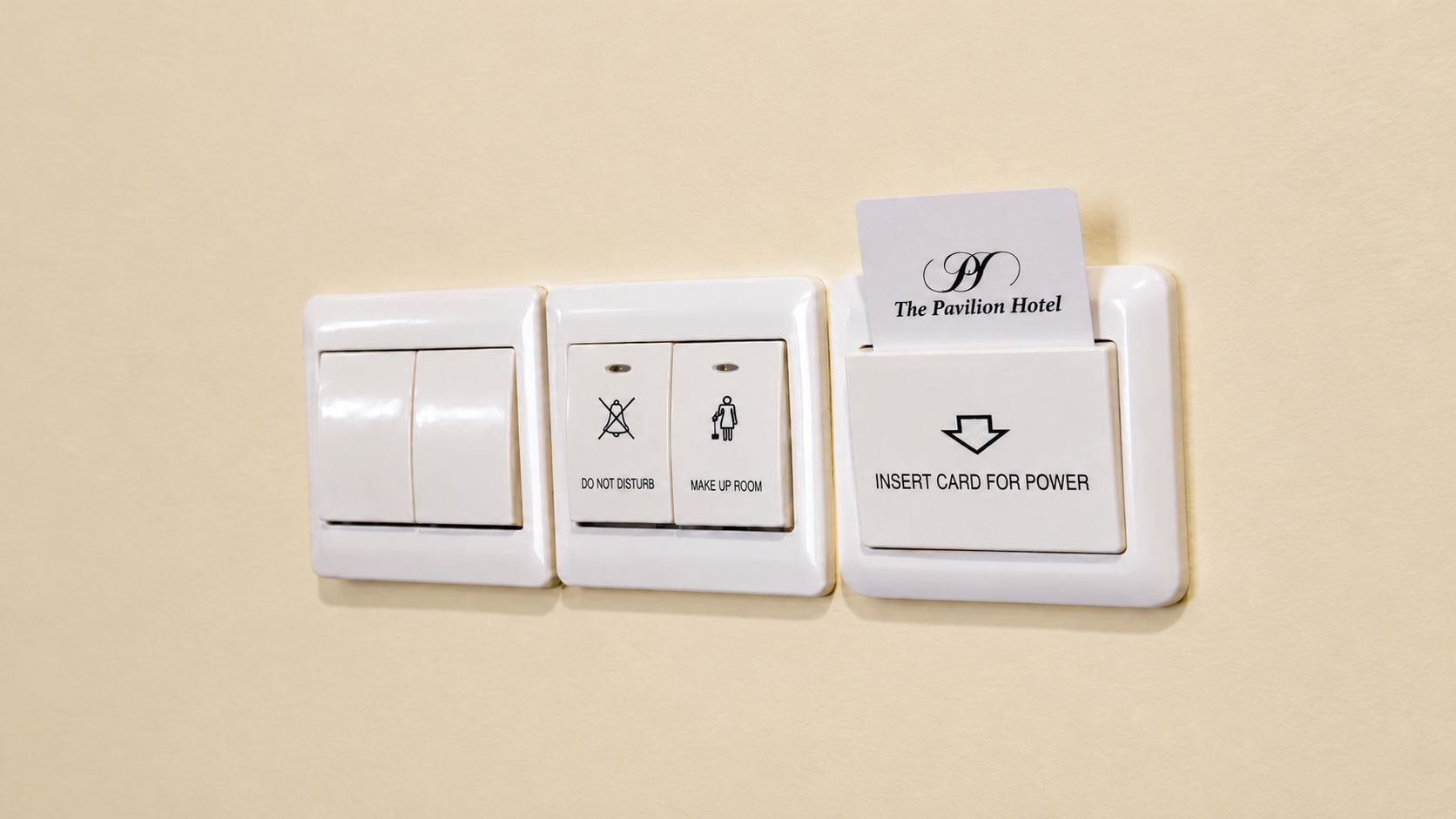 A wall-mounted control panel with three switches and a card reader for The Pavilion Hotel.