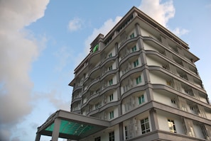 A multi-story building with balconies and a green sign on the top. - The Pavilion Hotel (Sandakan)