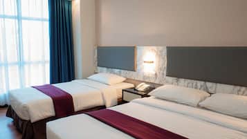 A hotel room with two beds, a nightstand, a telephone, and a window with curtains.