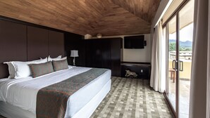 A bedroom with a large bed, a TV mounted on the wall, and a view of the outside through a sliding door. - Casa del Alma Hotel Boutique & Spa (San Cristóbal de las Casas)