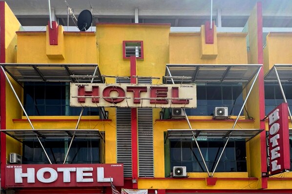 A hotel with a prominent 'HOTEL' sign in the center, multiple air conditioning units, and a red and yellow facade. - Batu Caves Business Hotel (Batu Caves)