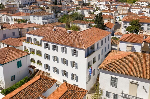 A densely packed urban area with white buildings featuring red-tiled roofs and multiple windows.