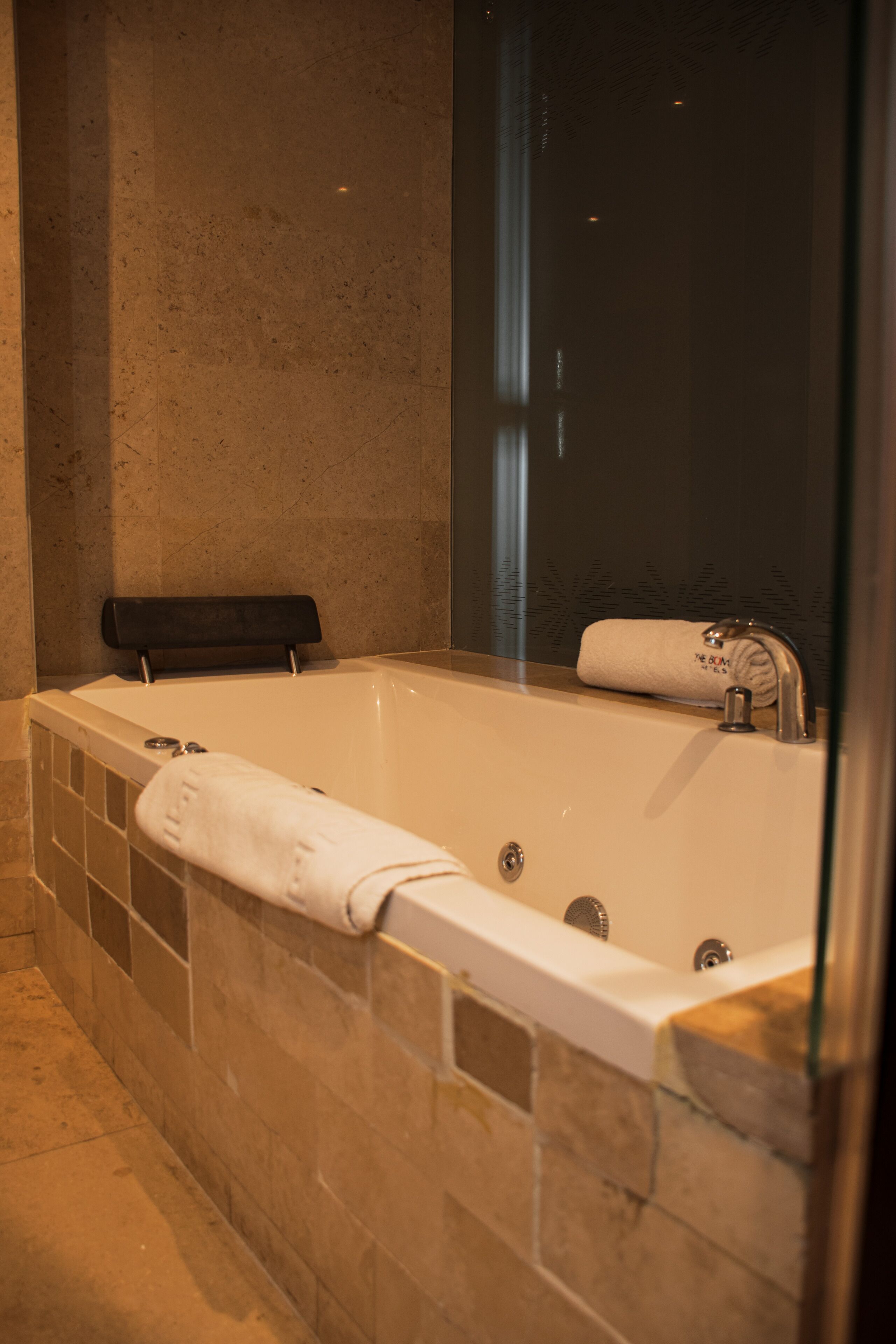 Un baño moderno con una bañera grande, cabina de ducha de vidrio y un perchero para toallas.
