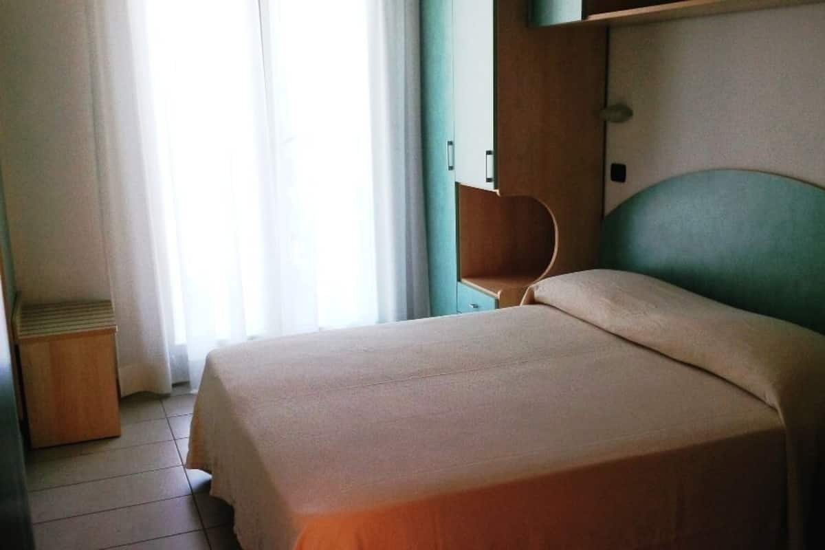 A neatly made bed in a room with a wooden headboard and a small bedside table.