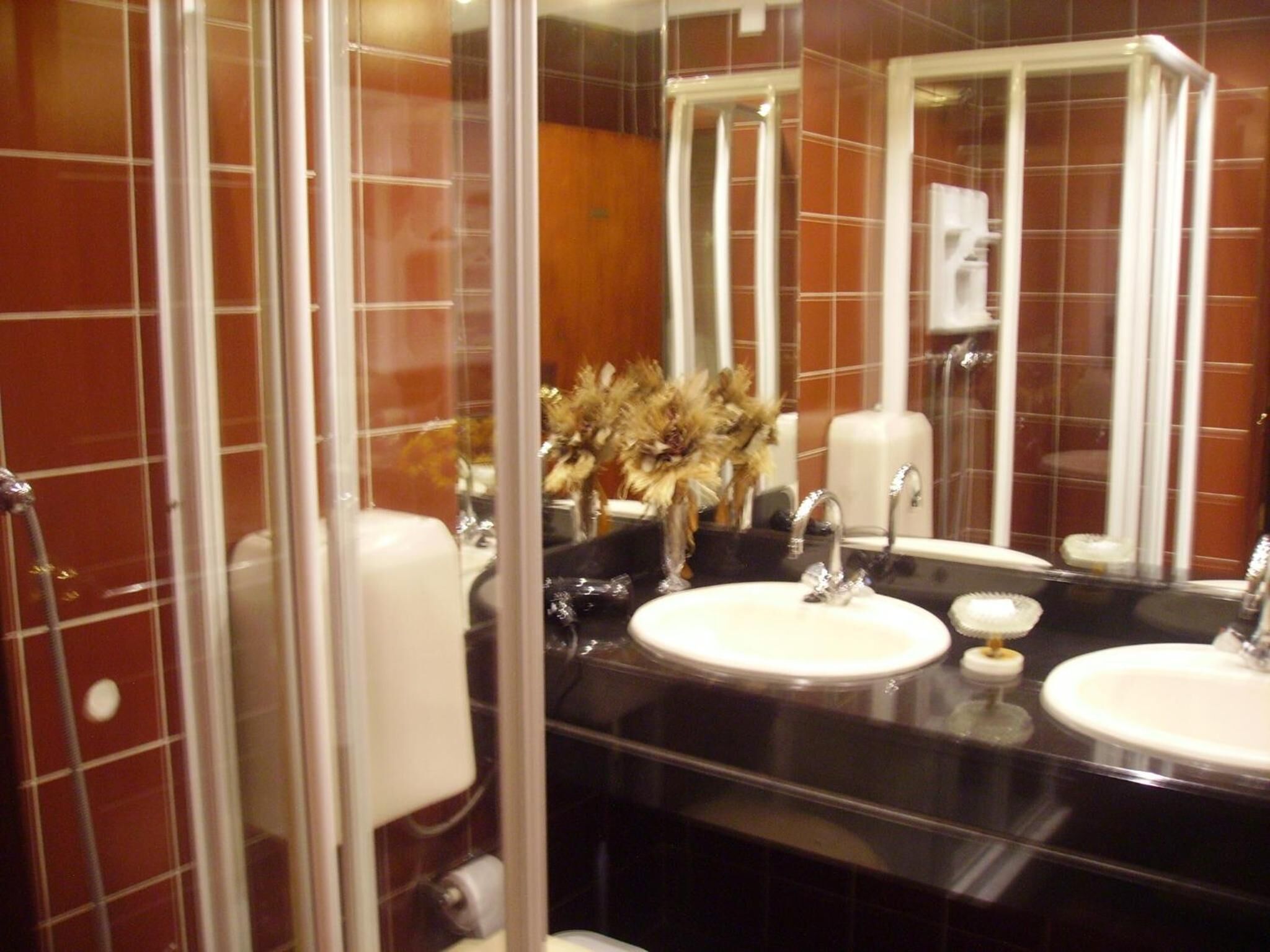 Un baño con dos lavamanos, un espejo y cabina de ducha.