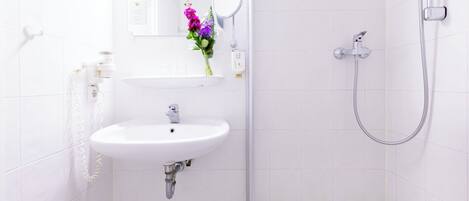 Ein Badezimmer mit Waschbecken, Spiegel und Dusche.