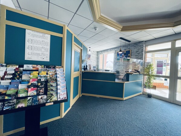 A reception area with a blue and white color scheme, a reception desk, and a wall with a map.