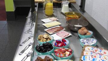 Una mesa de buffet con diversos alimentos y salsas.