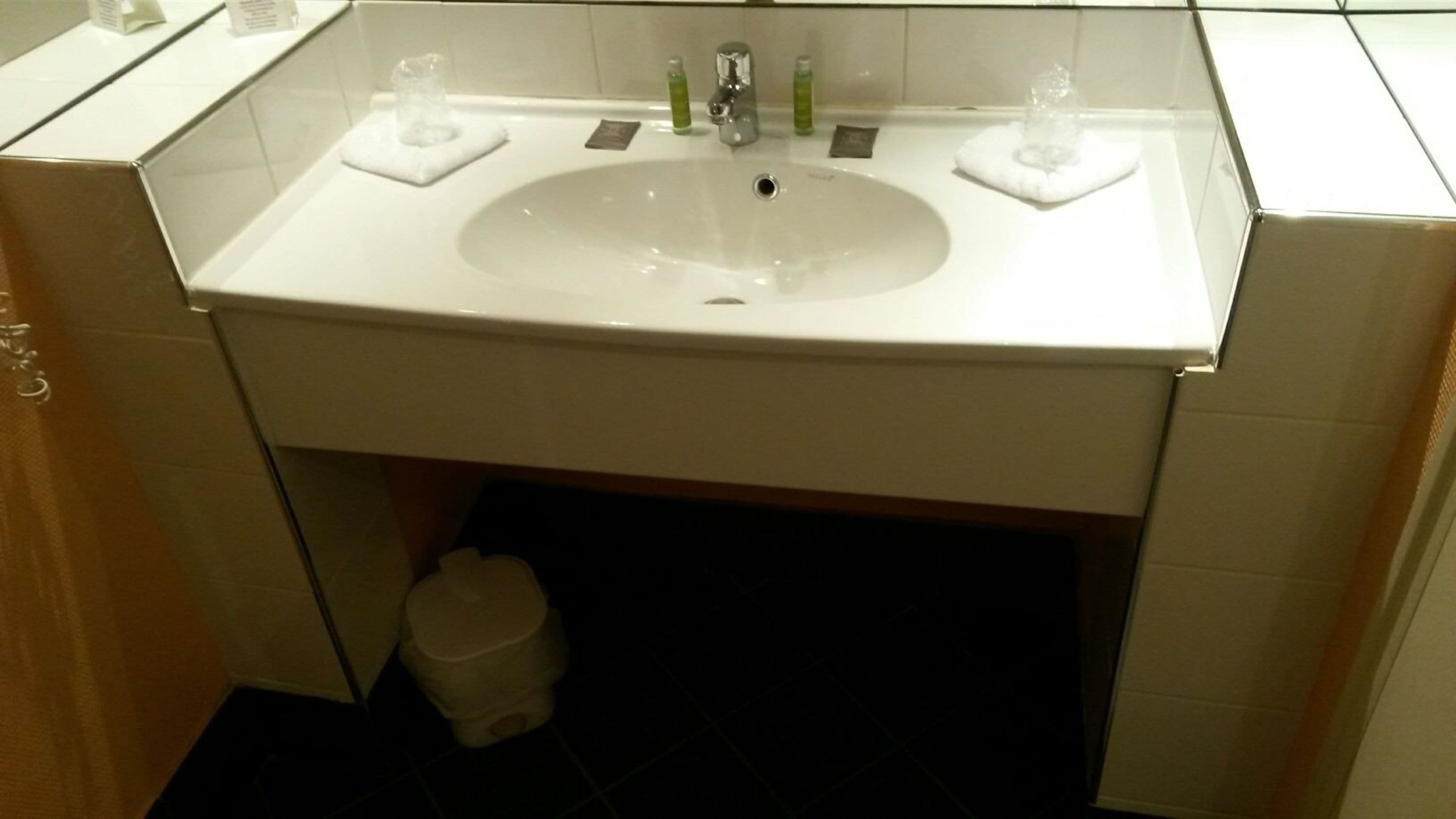 Et badeværelse med en hvid vask, to sæbedispensere og et toilet.
