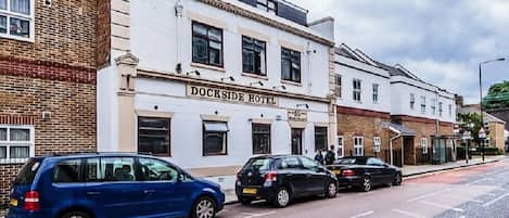 Un bâtiment portant l’inscription « Dockside Hotel », avec une façade en briques et un étage supérieur blanc.