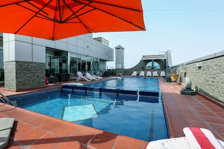 Outdoor pool, pool umbrellas, pool loungers. Royal Grand Suite Hotel