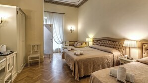 A hotel room with two beds, a sitting area, a desk, and a bathroom. - Hotel Labelle  (Rome)