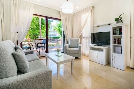 Premium Apartment, 1 Bedroom | Living area | Flat-screen TV, books