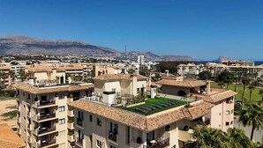 A multi-story hotel with balconies, a rooftop garden, and a view of mountains and the sea. - apartamentos Albir Confort (L'Alfas del Pi)