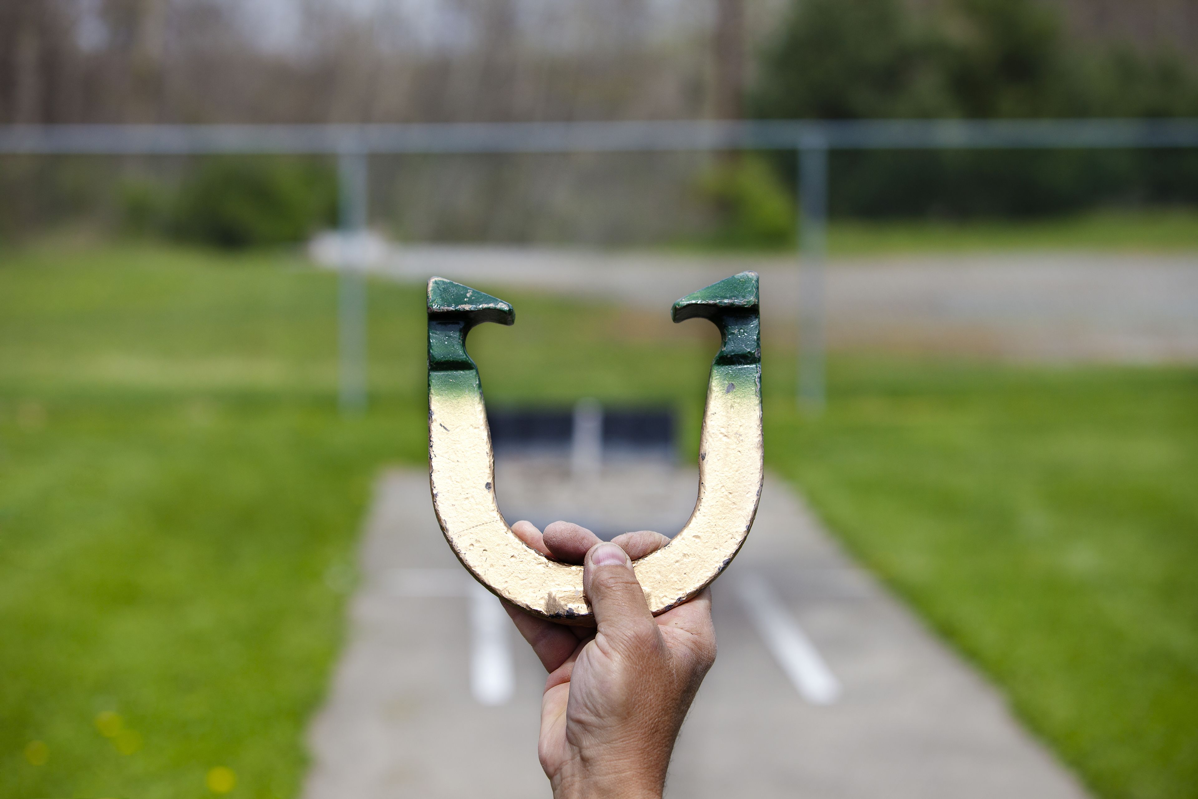 A hand holding a horseshoe.