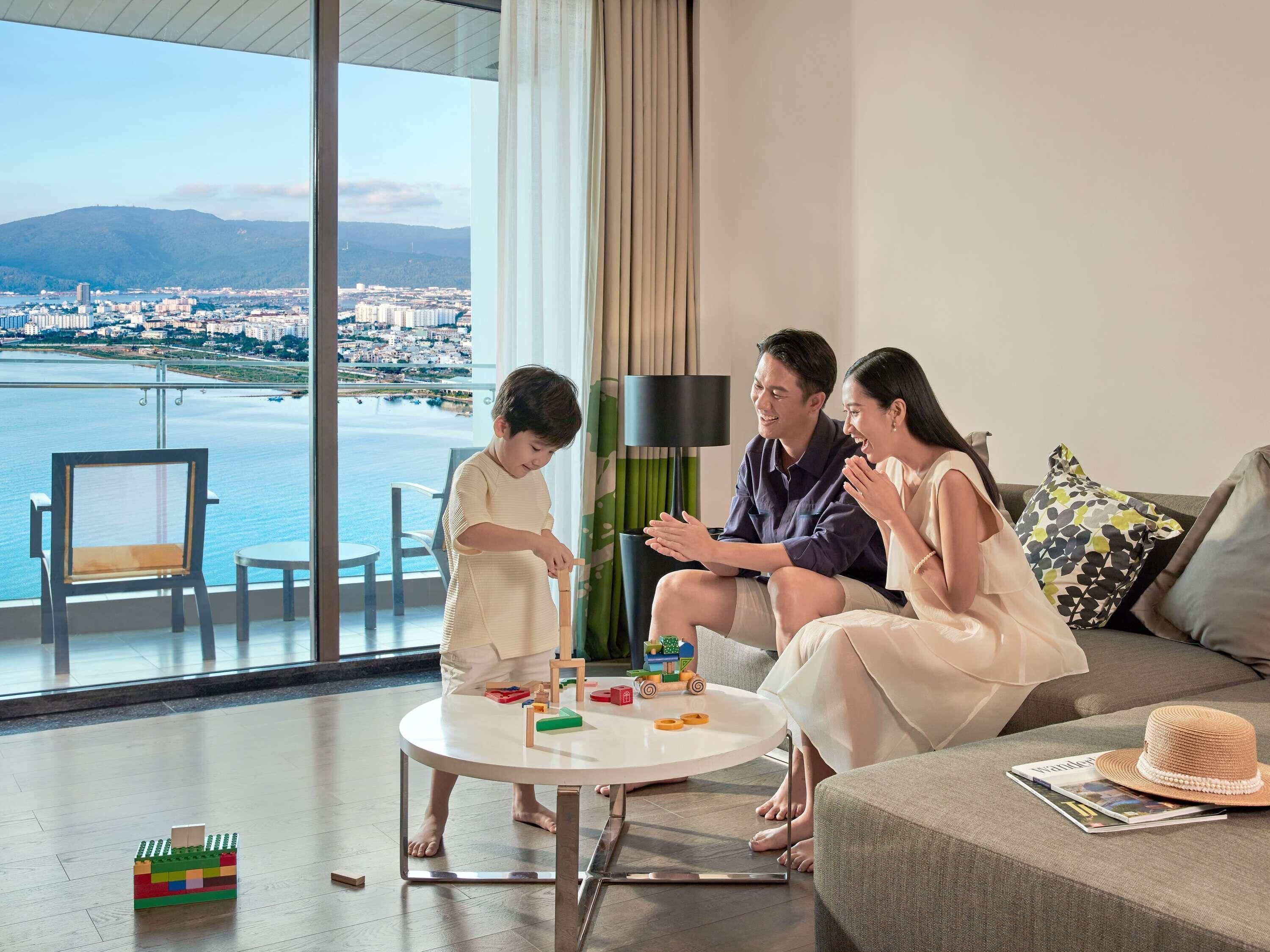 A modern living room with a large window overlooking a cityscape and water.