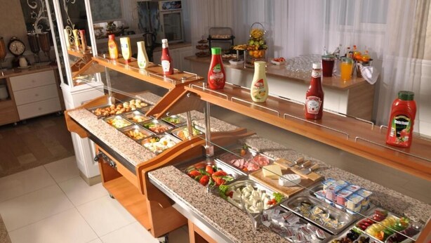 A buffet setup with various food items and condiments. - Bulevard Prestige Hotel (Slatina)