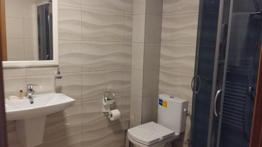 Un baño con lavamanos, inodoro y ducha.
