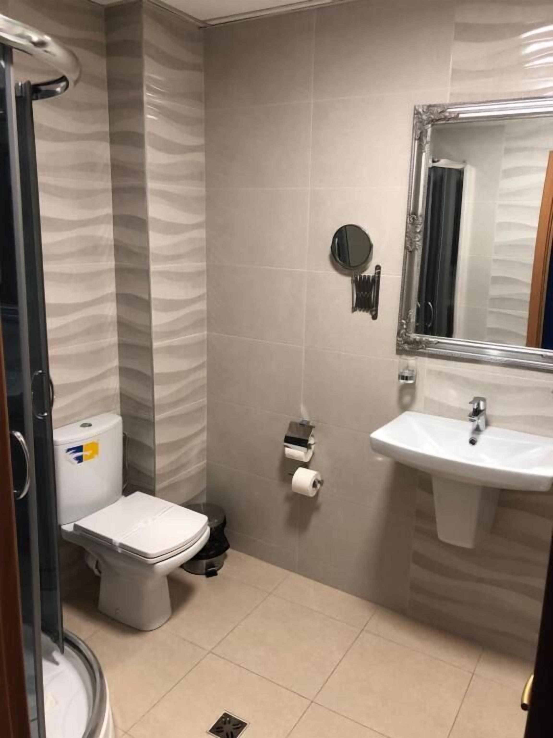 Ein Badezimmer mit Toilette, Bidet, Waschbecken und Spiegel.