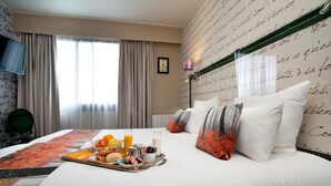 Une chambre d’hôtel avec un lit soigneusement fait, un plateau de petit-déjeuner, une télévision et une fenêtre avec des rideaux.