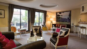 Un salon spacieux doté d’une grande fenêtre, d’une cheminée et d’un coin repas avec un bar.