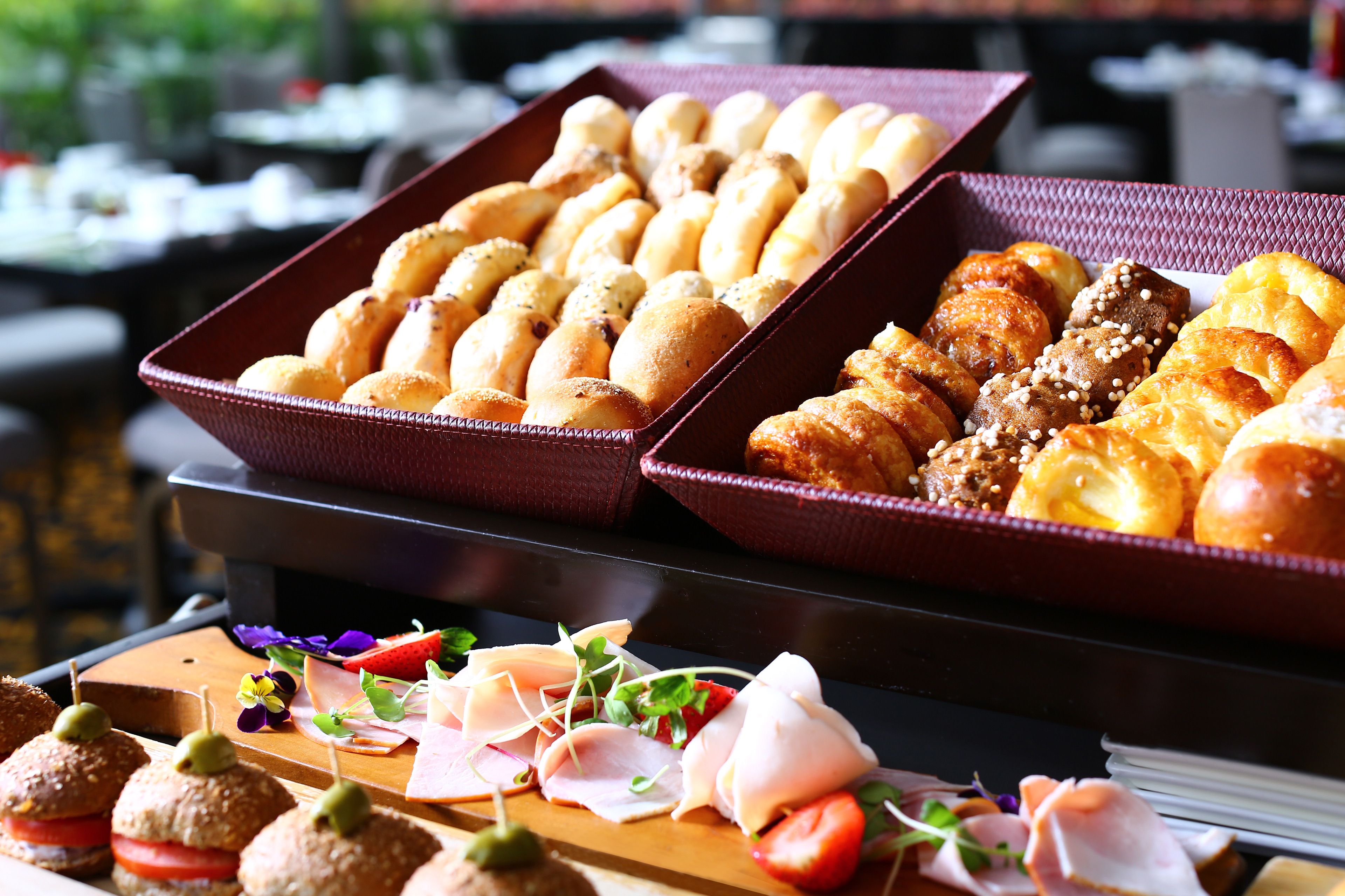 A buffet with various breads and pastries.