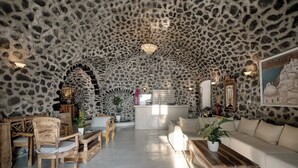 Una habitación amplia con techo de piedra, muebles de madera y una isla central.