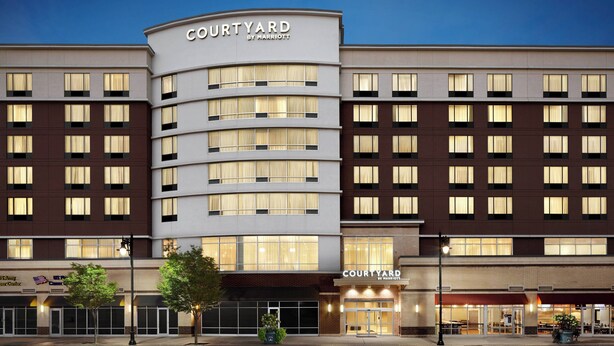 A Courtyard by Marriott hotel with a modern facade, multiple floors, and large windows. - Courtyard by Marriott Newark Downtown (Newark)