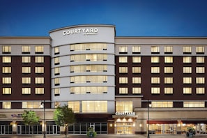 Un hotel Courtyard by Marriott con fachada moderna, varios pisos y grandes ventanales.