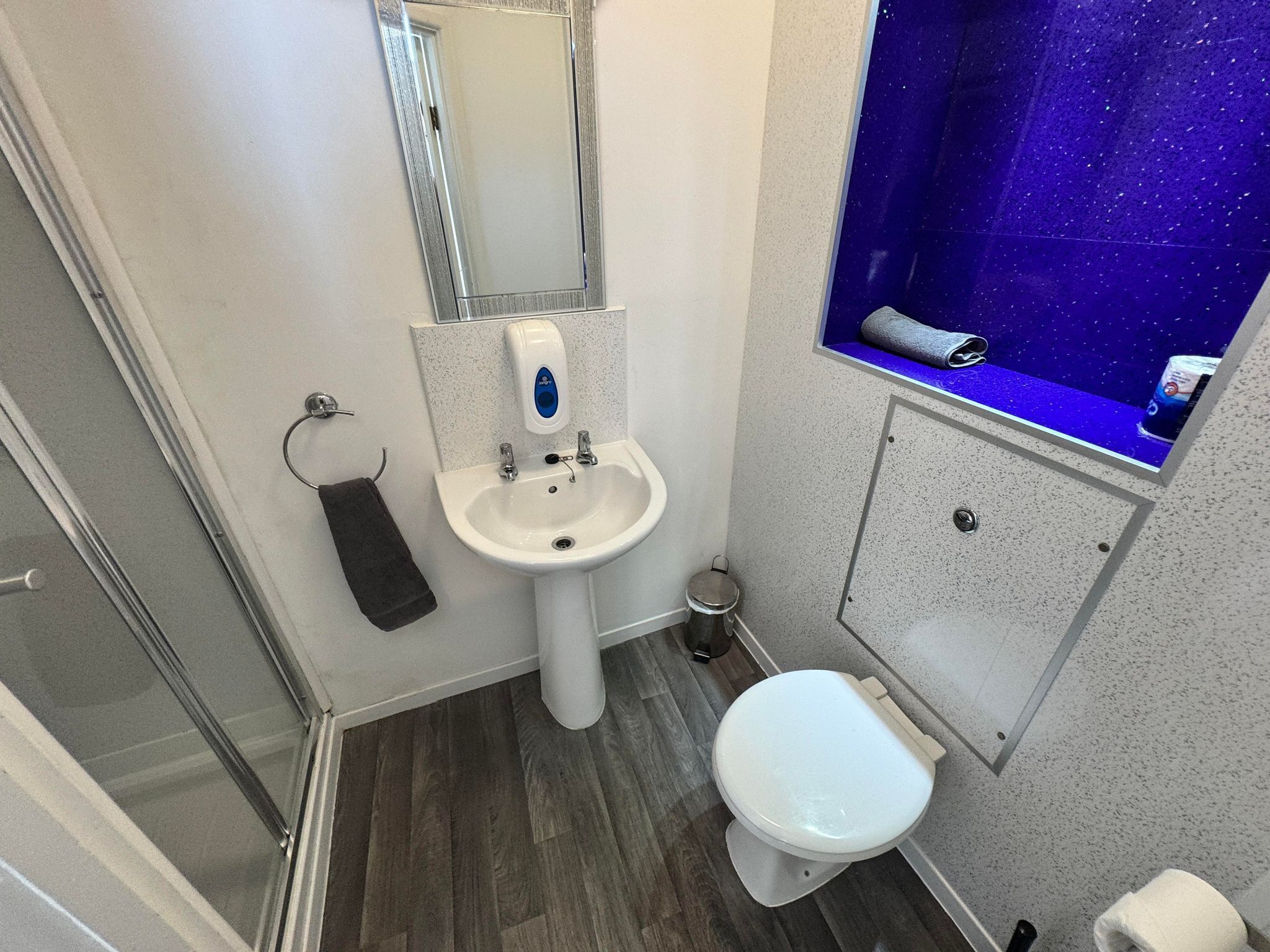 Un bagno con lavandino, specchio e water bianchi.