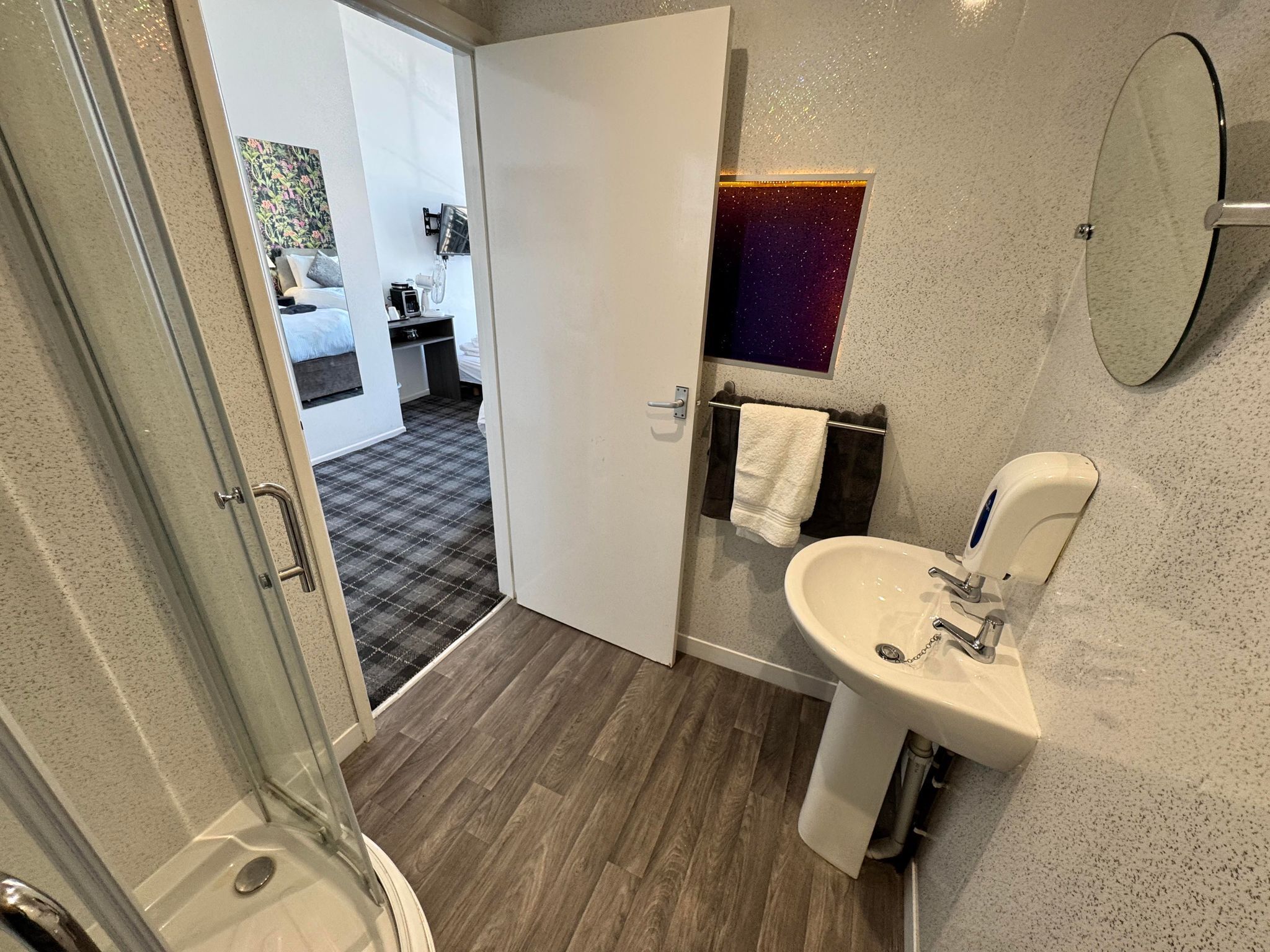 Un baño moderno con ducha, lavabo y espejo.