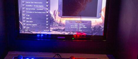 A gaming setup with a TV displaying a game menu and a joystick.
