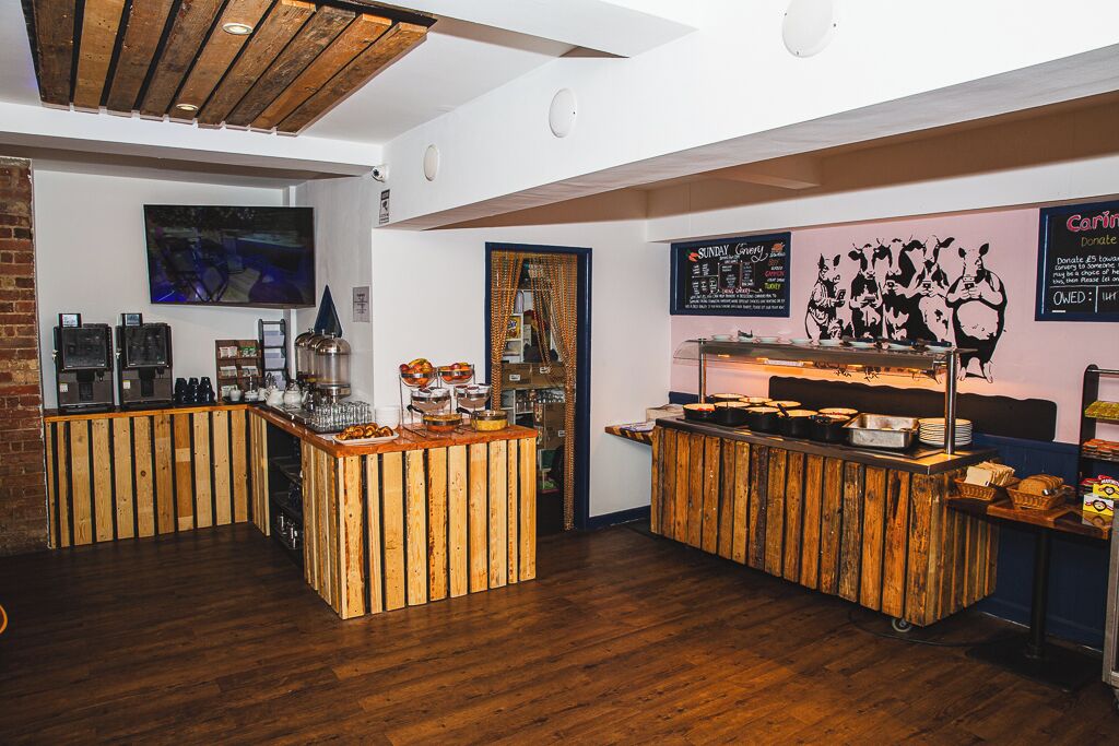 A bar area with wooden counters and a wall-mounted TV.